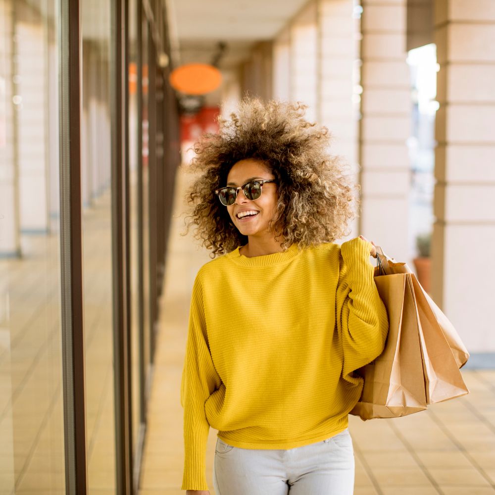 Lady with curly hair carrying some shopping bags